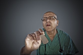 Doctor holding a tongue depressor. Photo : Dan Bannister