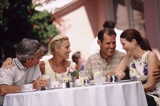 Two couples having dinner on the patio of a restaurant. Photo : Rob Lewine