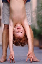 Father helping his son do a hand stand. Photo : Rob Lewine