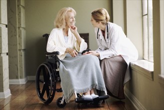 Doctor talking to woman in wheelchair. Photo : Rob Lewine