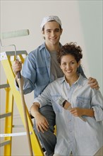 Happy couple painting the walls in their home. Photo : Rob Lewine