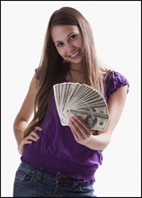 Teenage girl holding several 100 dollar bills. Photo : Mike Kemp