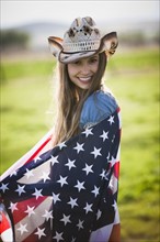 Beautiful cowgirl wrapped in American flag. Photo : Mike Kemp