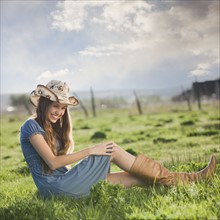 Cowgirl relaxing in field. Photo : Mike Kemp