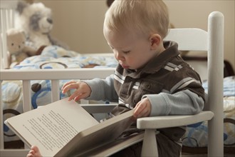Toddler looking at a book. Photo : Mike Kemp