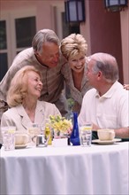 Two senior couples socializing on restaurant patio. Photo : Rob Lewine