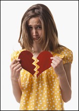 Teenage girl holding broken heart. Photo : Mike Kemp