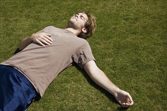 Defeated athlete lying on the grass. Photo : Stewart Cohen