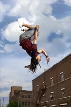 Teenage boy doing back flip in air. Photo : Stewart Cohen