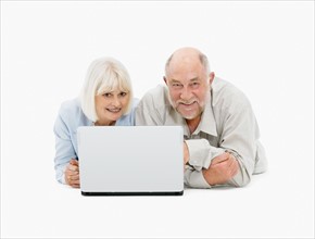 Retired couple looking at laptop together. Photo : momentimages