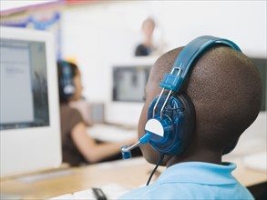 Elementary student wearing headphones in classroom.