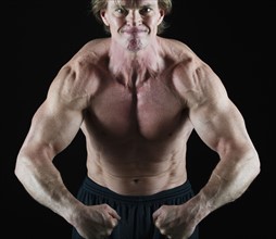 Muscular man flexing his muscles. Photo : Daniel Grill