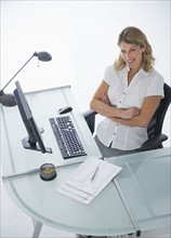 Confident businesswoman sitting at modern desk.