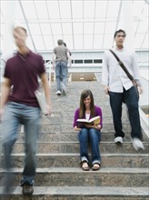 College students on steps in front of library.