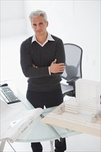 Architect standing behind his desk.