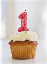 Lit candle on cupcake for first birthday celebration. Photo : Jamie Grill