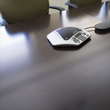Conference call device on desk in meeting room.
