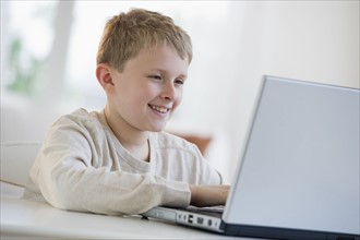Young boy looking at laptop.