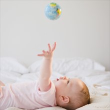 Baby reaching for globe. Photo. Jamie Grill