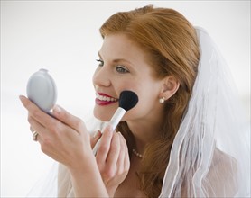 Bride putting on blush. Photo. Jamie Grill