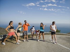 Runners stretching on a road in Malibu.