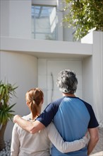 Couple looking at their home. Photo. momentimages