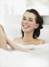 Woman relaxing in bathtub. Photo. momentimages
