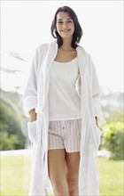 Smiling brunette woman wearing a bathrobe. Photo. momentimages