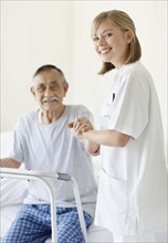 Nurse assisting patient with a walker. Photo. momentimages