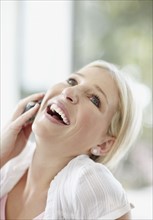Pretty blond woman talking on phone. Photo. momentimages