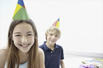 Two children wearing birthday hats. Photo : momentimages