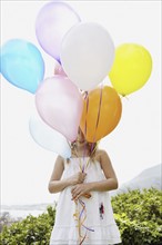 Young girl holding balloons. Photo. momentimages