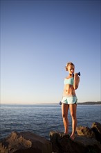 Athletic woman lifting weights outdoors. Photo : Take A Pix Media