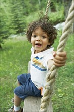 Cute young child sitting on swing. Photo. Shawn O'Connor