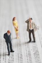 Figurines of people standing on stock chart. Photo. Antonio M. Rosario