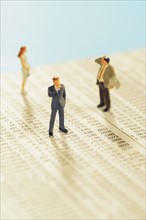 Figurines of people standing on stock chart. Photo. Antonio M. Rosario