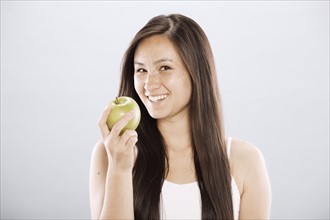 Brunette woman holding an apple. Photo. FBP