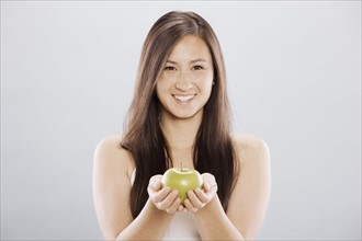 Brunette woman holding an apple. Photo. FBP