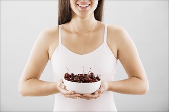 Woman holding a bowl of cherries. Photo. FBP