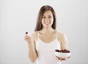 Woman holding a bowl of cherries. Photo : FBP
