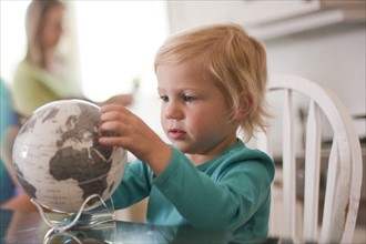 Young girl looking at globe. Photo : Tim Pannell