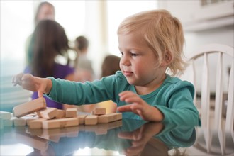 Young girl playing with wooden blocks. Photo. Tim Pannell