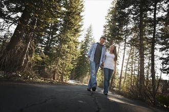 Couple walking hand in hand on a country road. Photo : FBP
