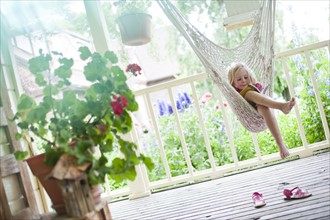 Young girl reading in hammock. Photo. Tim Pannell