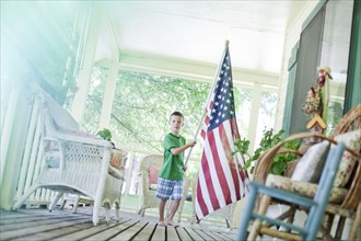 Young boy carrying American flag. Photo. Tim Pannell