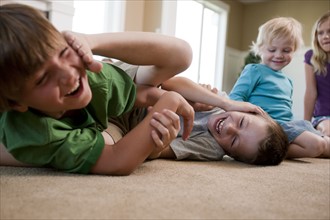 Children play fighting on floor. Photo : Tim Pannell
