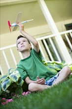 Young boy playing with toy airplane. Photo. Tim Pannell