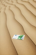 100 euro bill on sand in desert. Photo. Mike Kemp