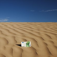 100 euro bill on sand in desert. Photo. Mike Kemp