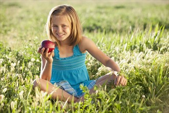 Young girl eating an apple. Photo. Mike Kemp